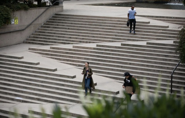 Legally “accessible,” but not actually accessible, entrance to a public building in Vancouver, Canada. Note the lack of handrails or raised edges on the ramp so that a wheelchair user can easily roll off ramp and land face-first on the concrete steps. Also, note the steep grade.